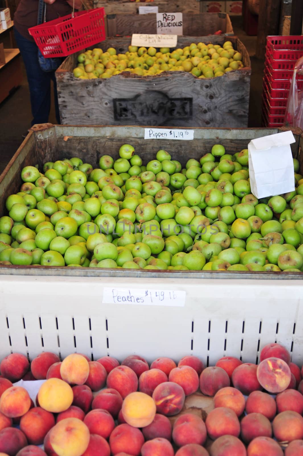 Fresh fruit on display at a farmers market, peaches and different kinds of apples.