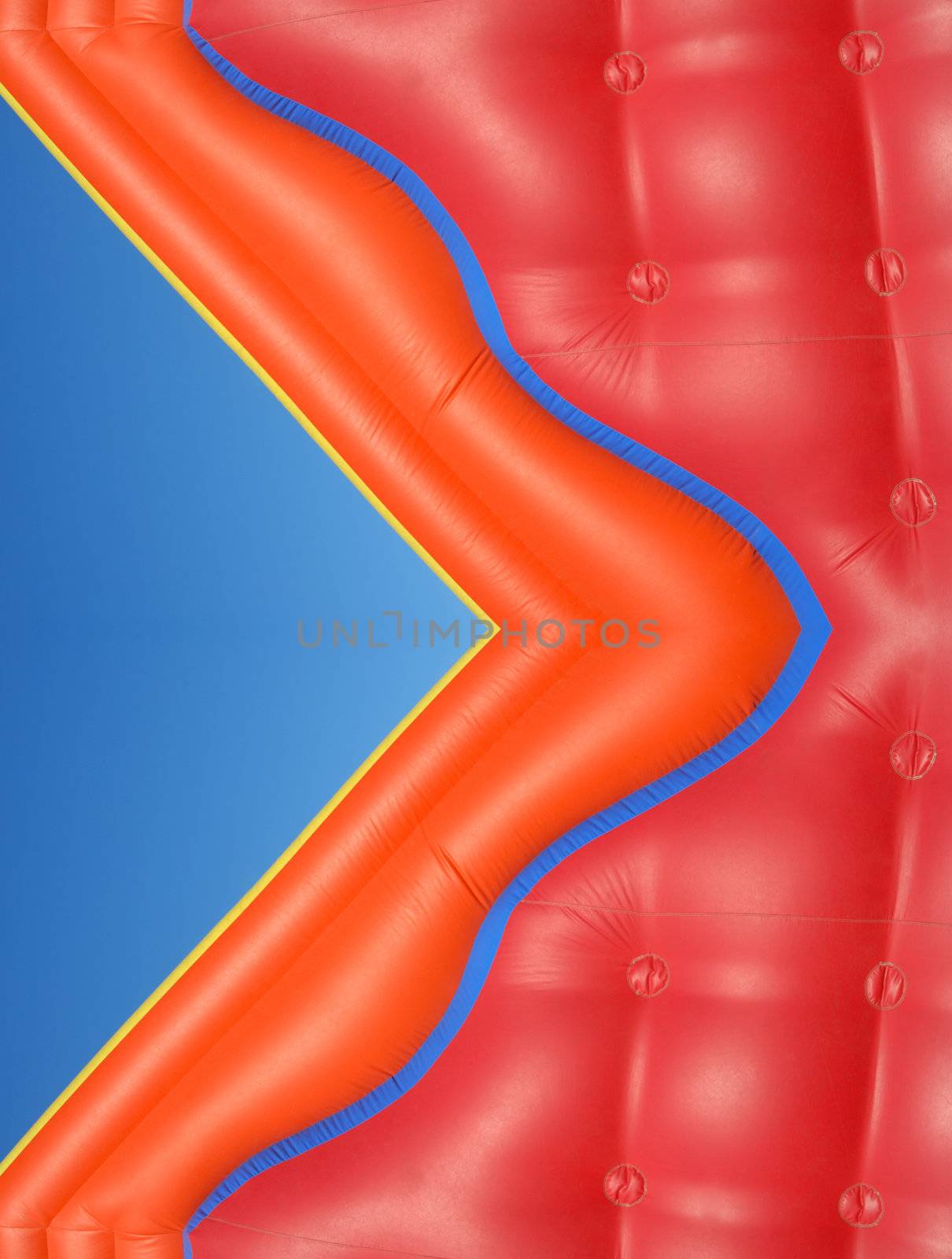 Partial view of a colorful inflatable blow-up toy on blue sky background 