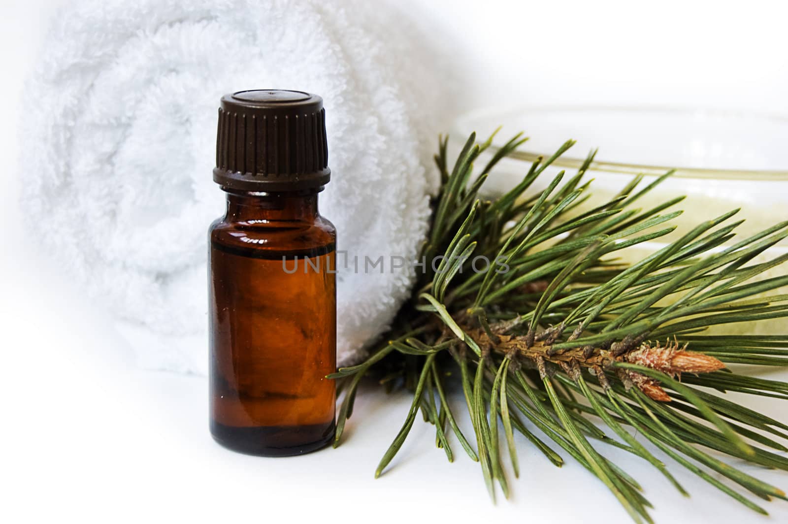 Bottle of fir tree oil and towel over white