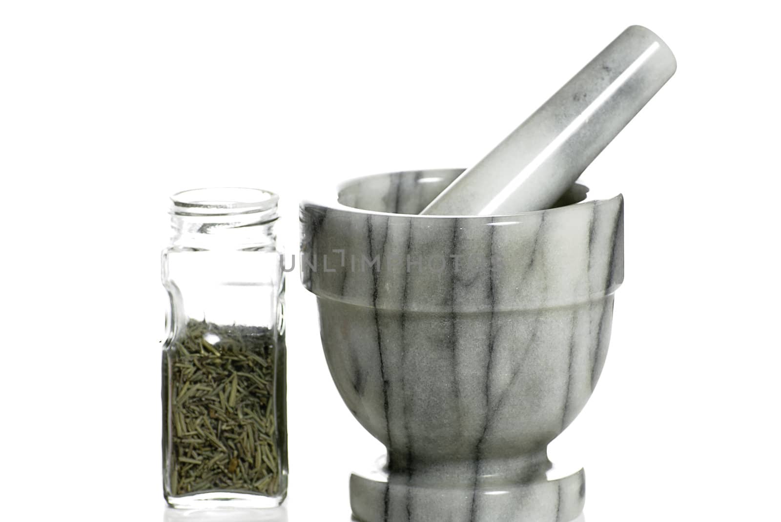 A marble mortar and pestle used to grind spices is isolated against a white background.