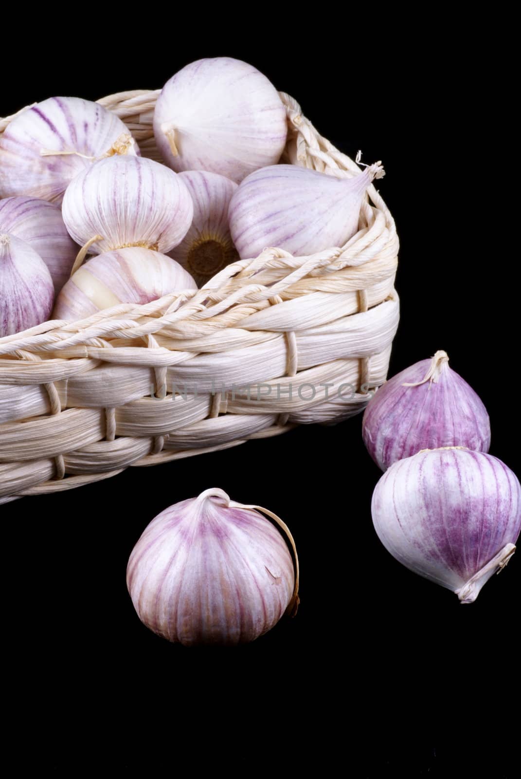 Wonderful garlic in little basket isolated on black.