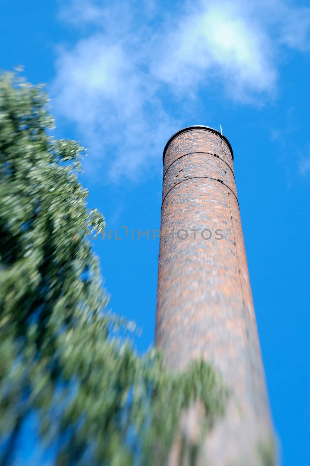 Old factory chimney made of brick. The zoom blur effect is achieved in-camera through use of Lensbaby.
