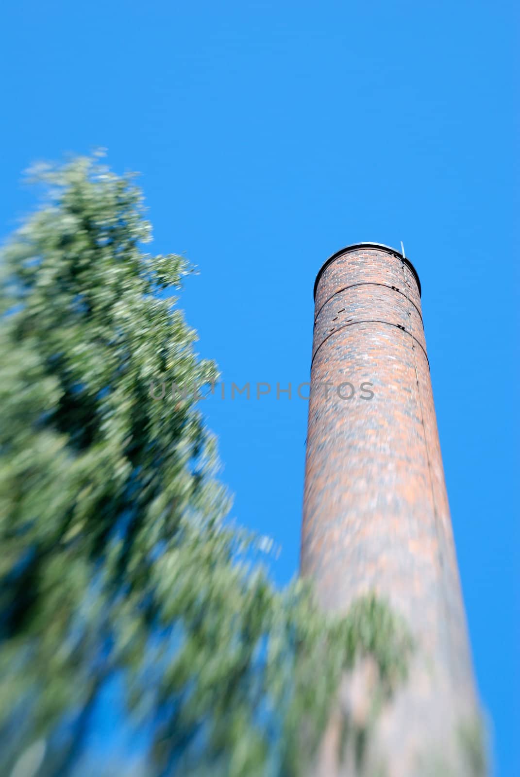 Old factory chimney made of brick. The zoom blur effect is achieved in-camera through use of Lensbaby.

