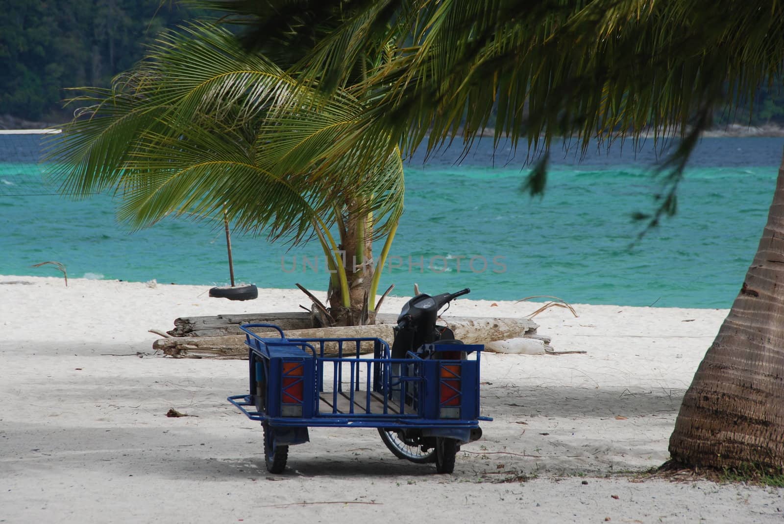 Motorcycle and cart on a tropical beach