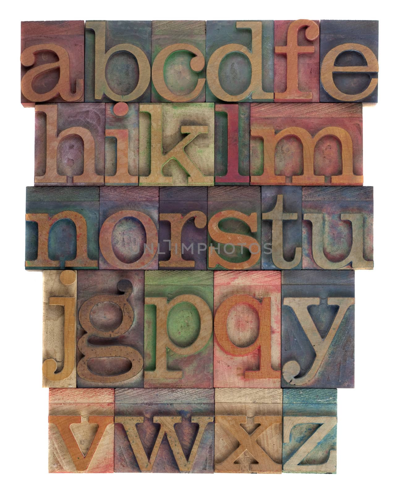 English alphabet (lower case) in vintage wooden letterpress type, stained by  inks of different colors, flipped horizontally, isolated on white