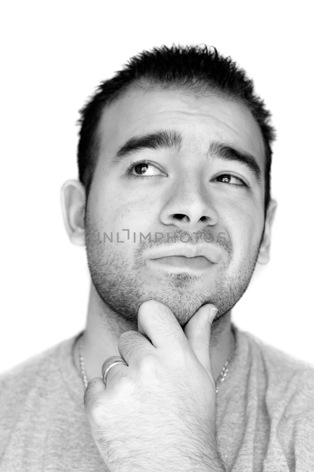A young man with his hand on his chin thinking an important decision - black and white.
