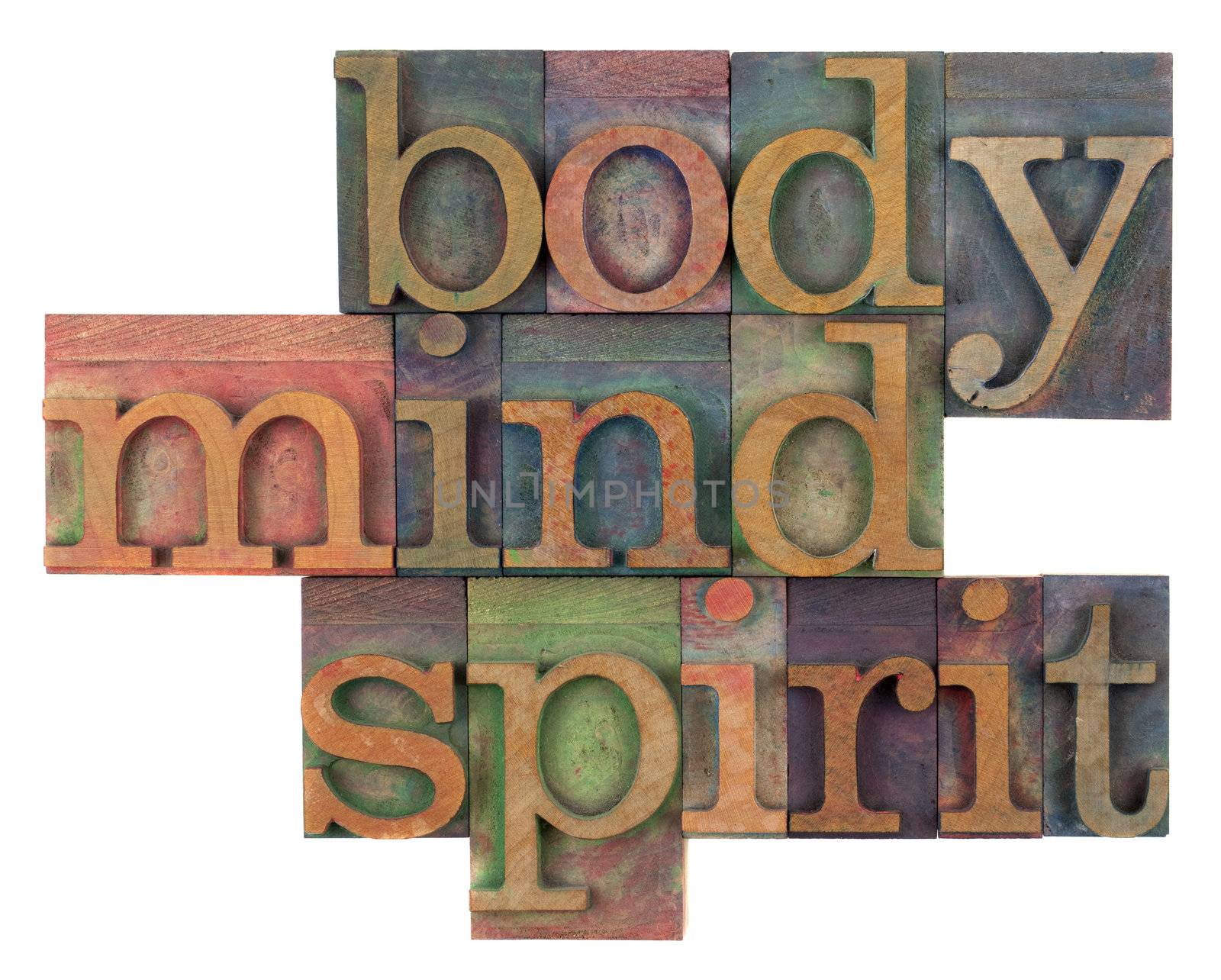 body, mind and spirit in vintage wooden letterpress types, stained by ink in different colors, isolated on white