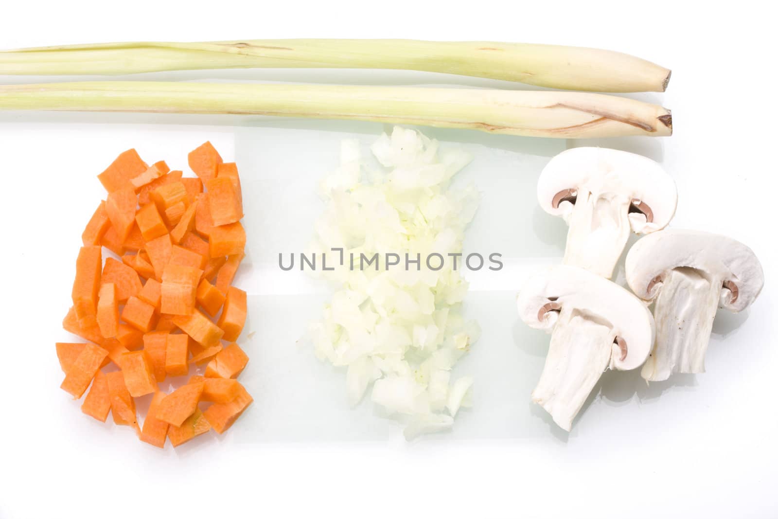 sliced carrots, onions and champignons on a glass chopping board