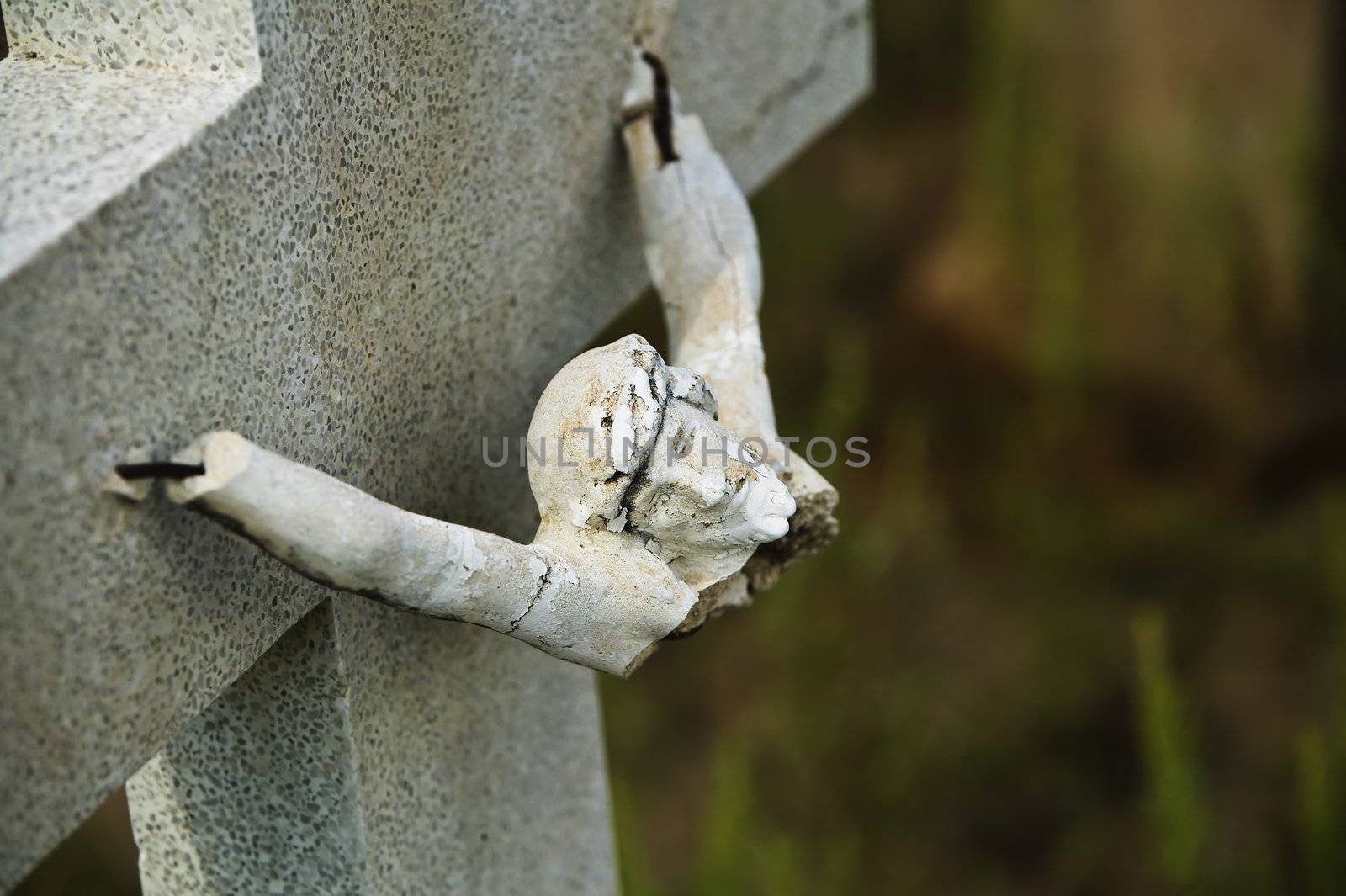 Broken figure of jesus Christ on a grave marker