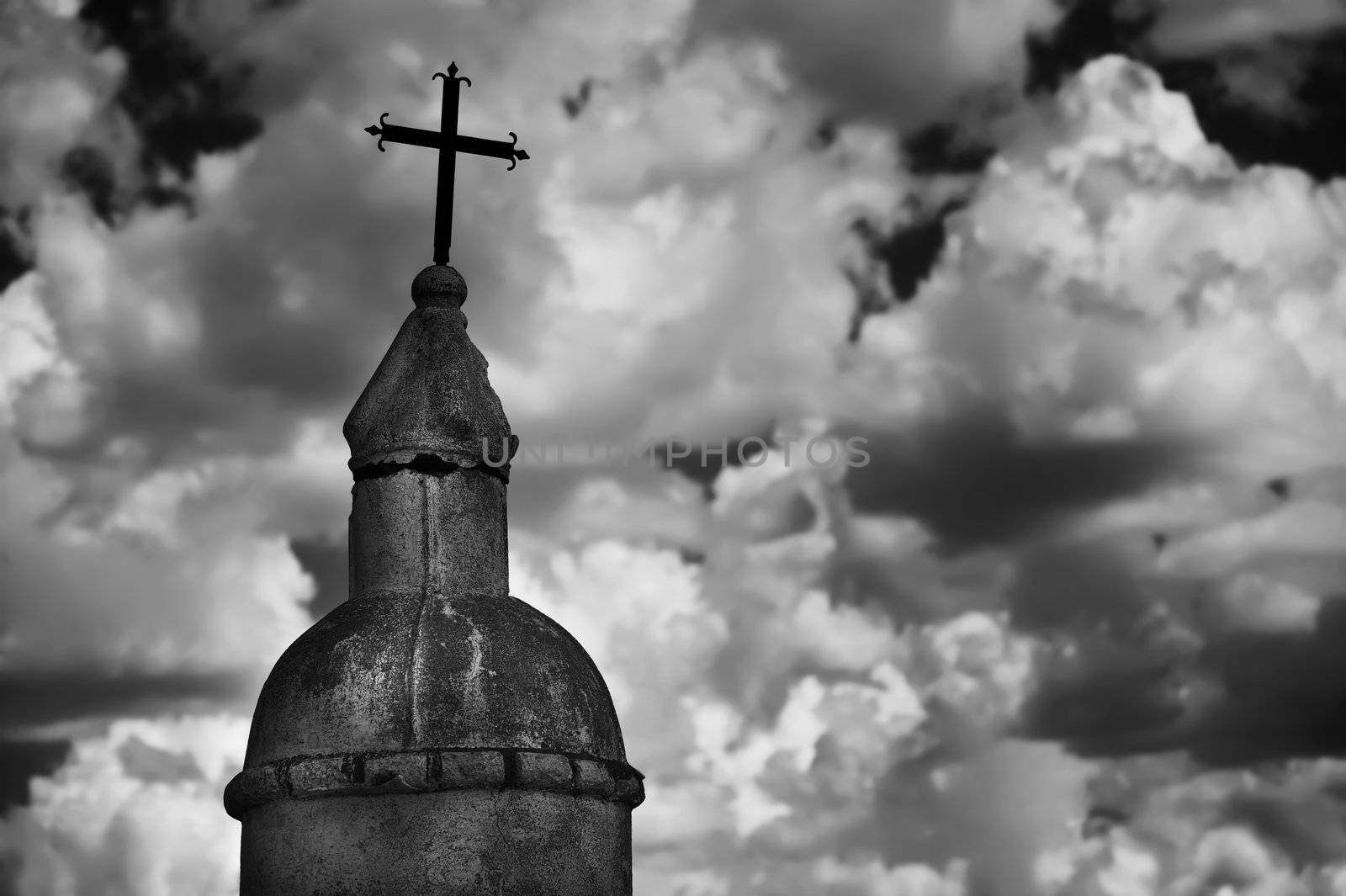 Black and white religious monument against a cloudy sky