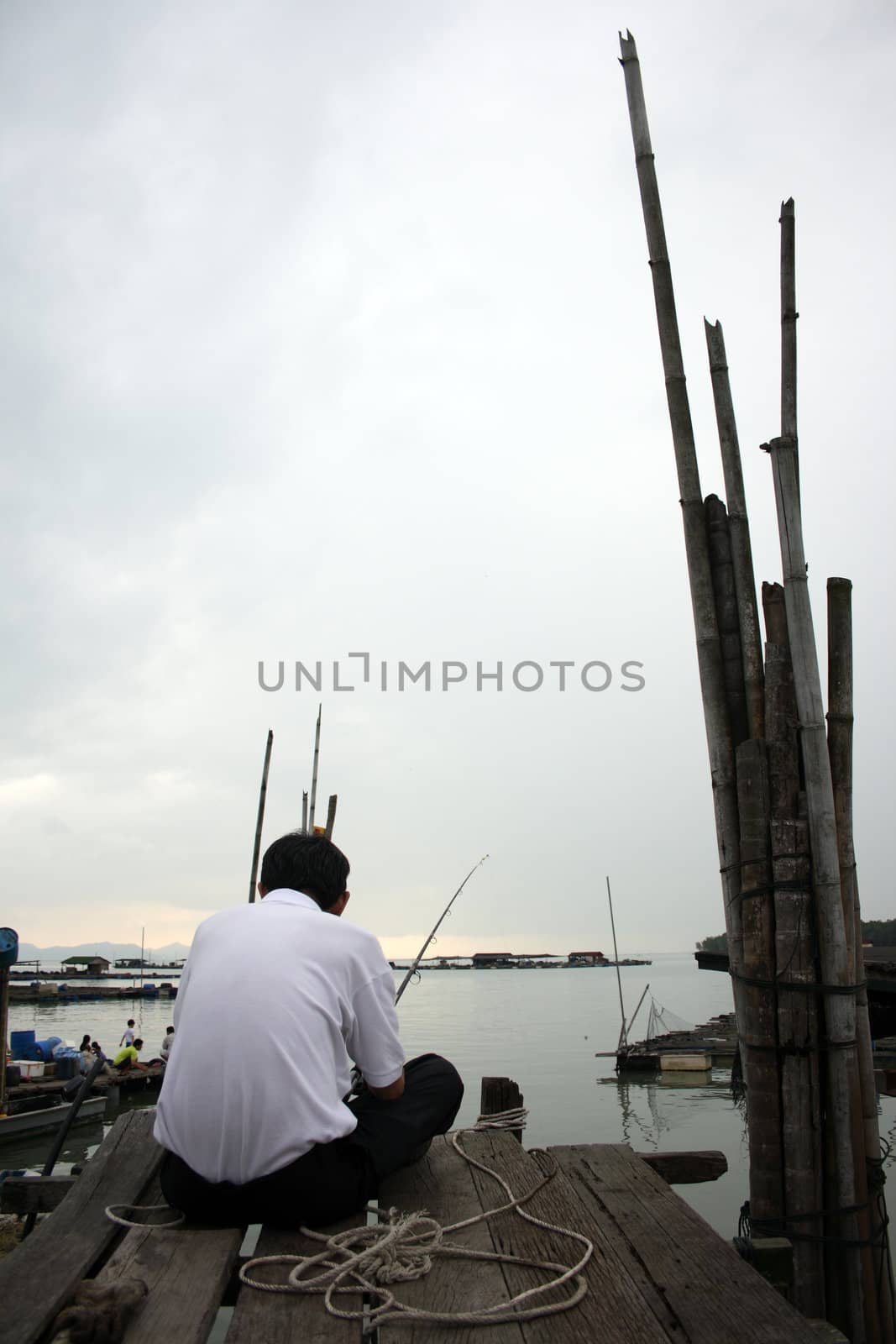 A city man fishing in a fishing village.