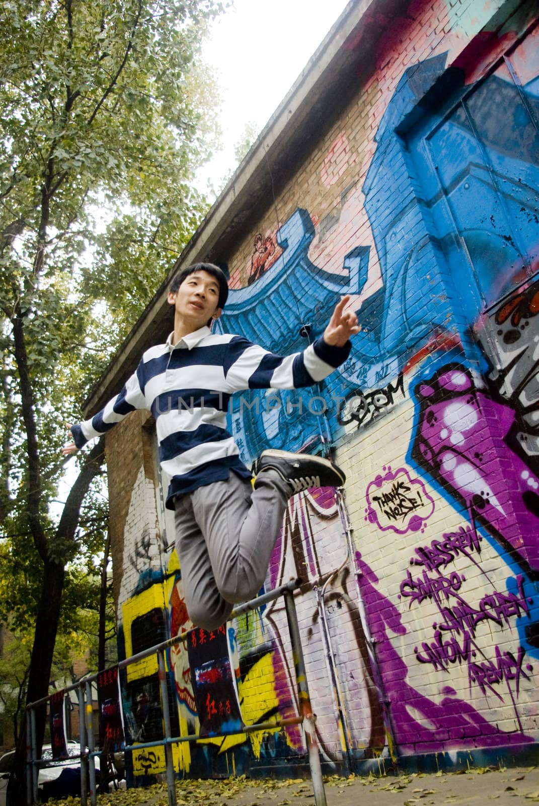 it is a  a young man jump with graffiti background
