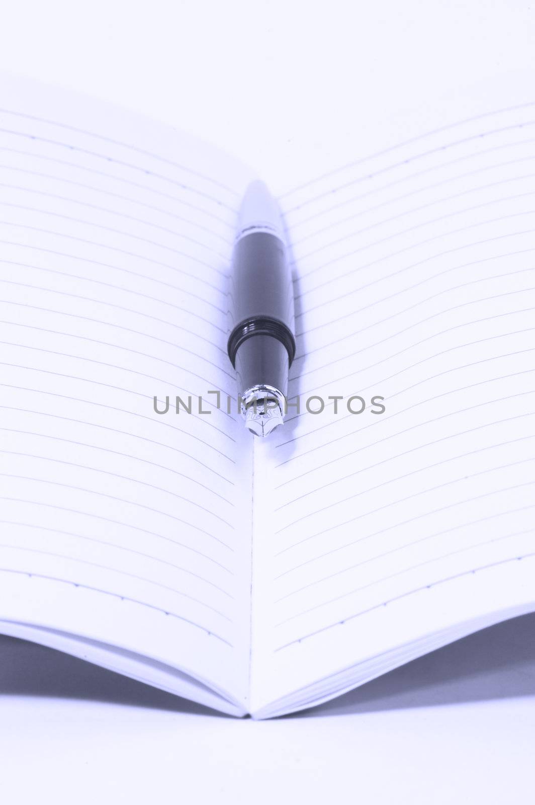 classic black fountain pen on open notebook,blue filter