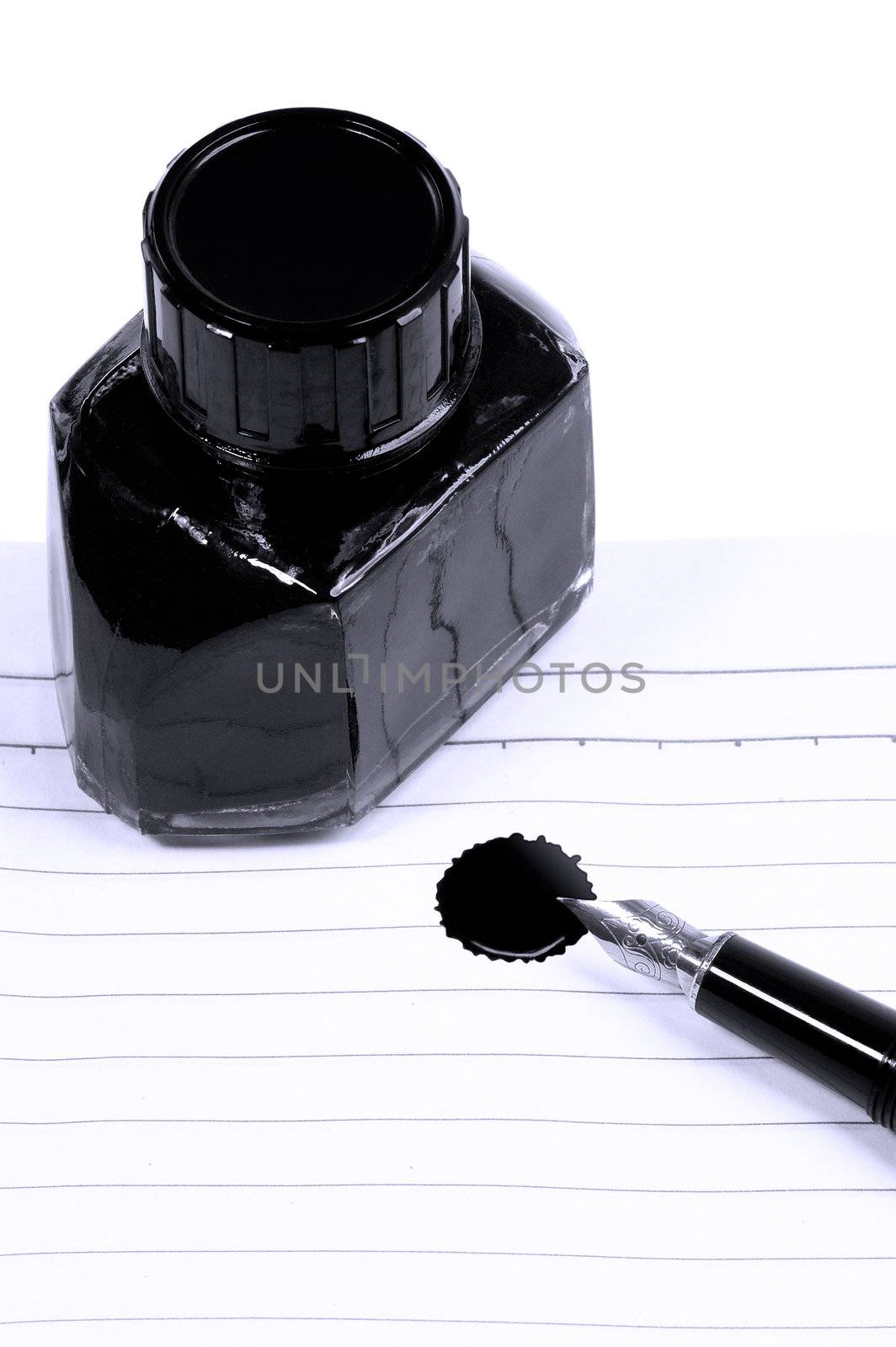 classic black fountain pen on open notebook with ink bottle with stain on page,blue filter