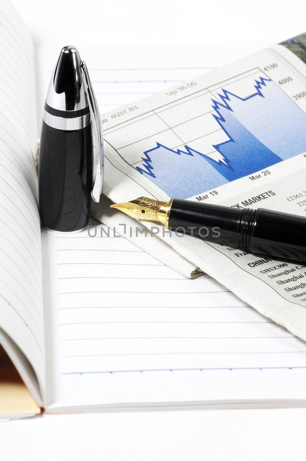 notebook  newspaper and fountain pen on white background