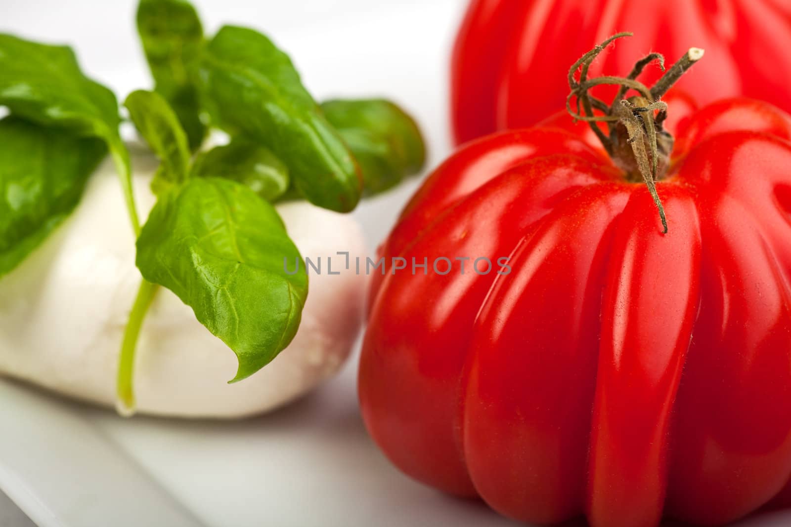 tomatoes, mozzarella and basil while making insalada caprese