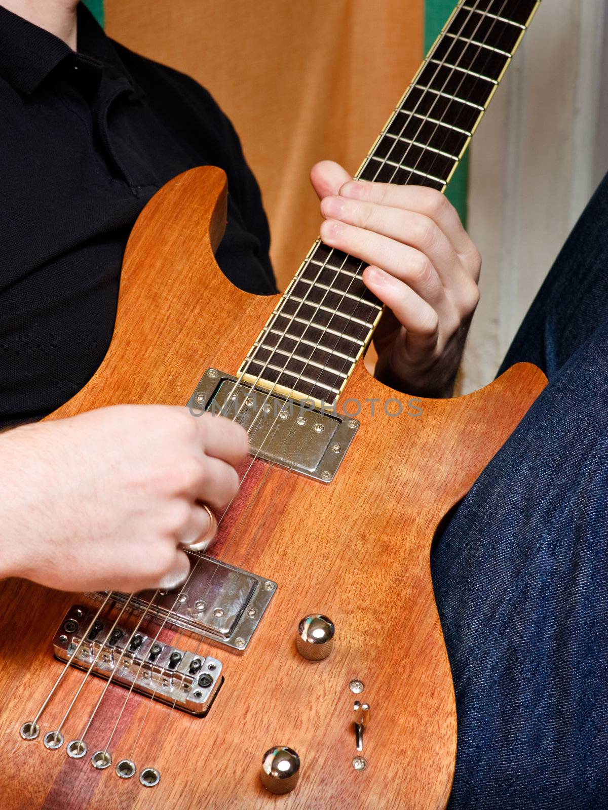 Musician playing electric guitar made of wood