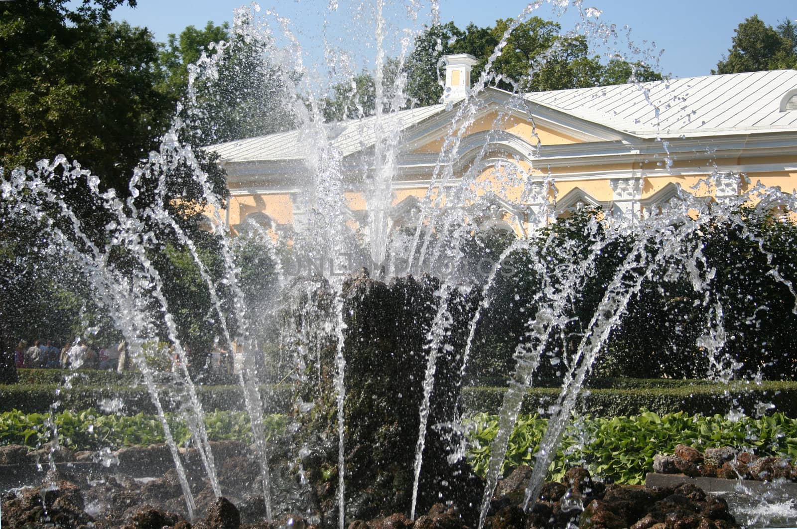 fountain in the park with yellow building
