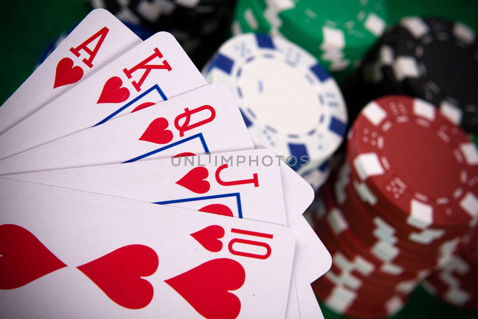 Cards with poker arrangement and poker chips in the background.