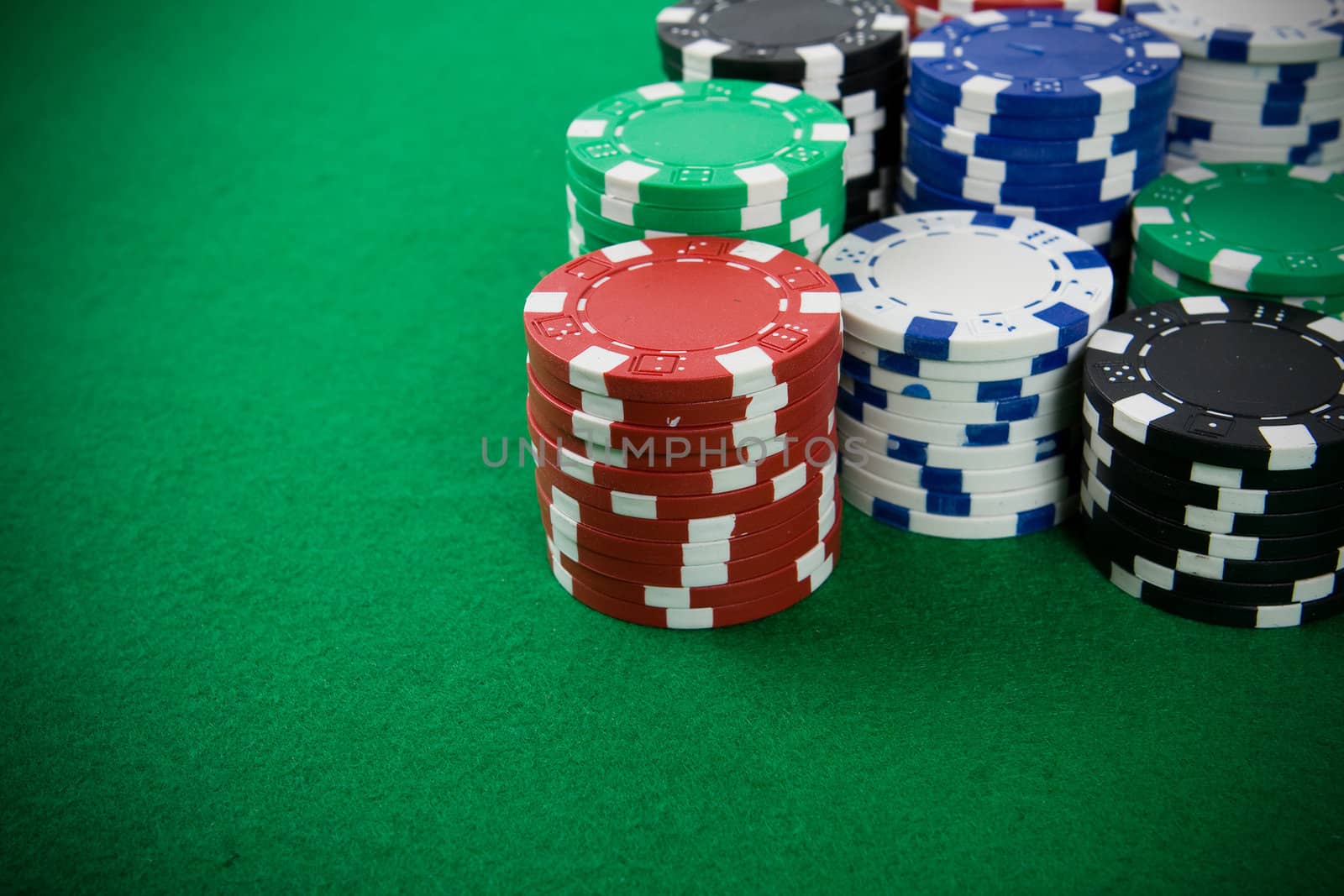 Stack of poker chips on green background.