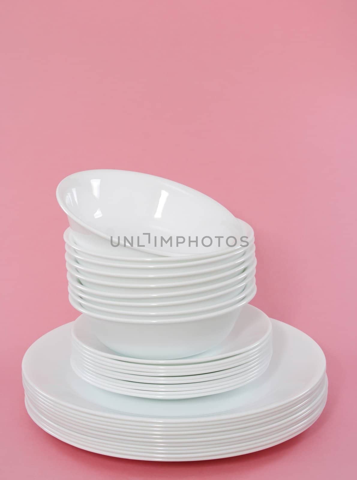 white dishes stacked, pink background 