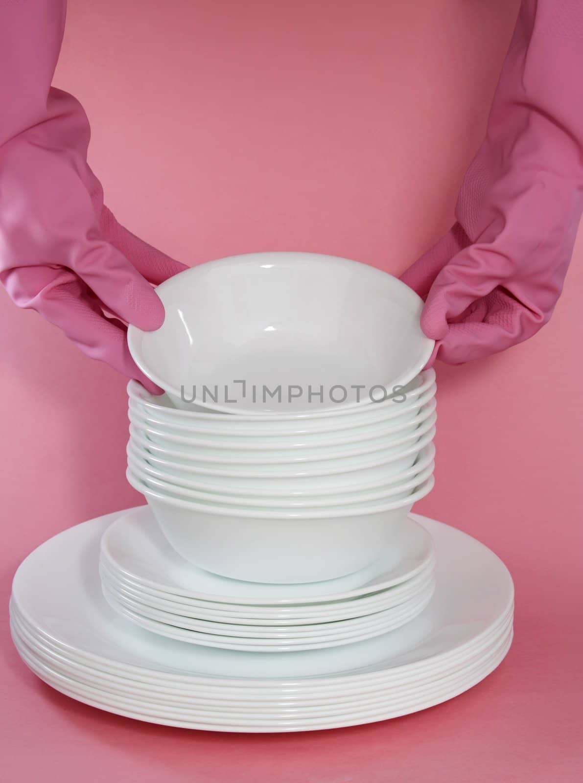 hand with pink glove holding white dishes