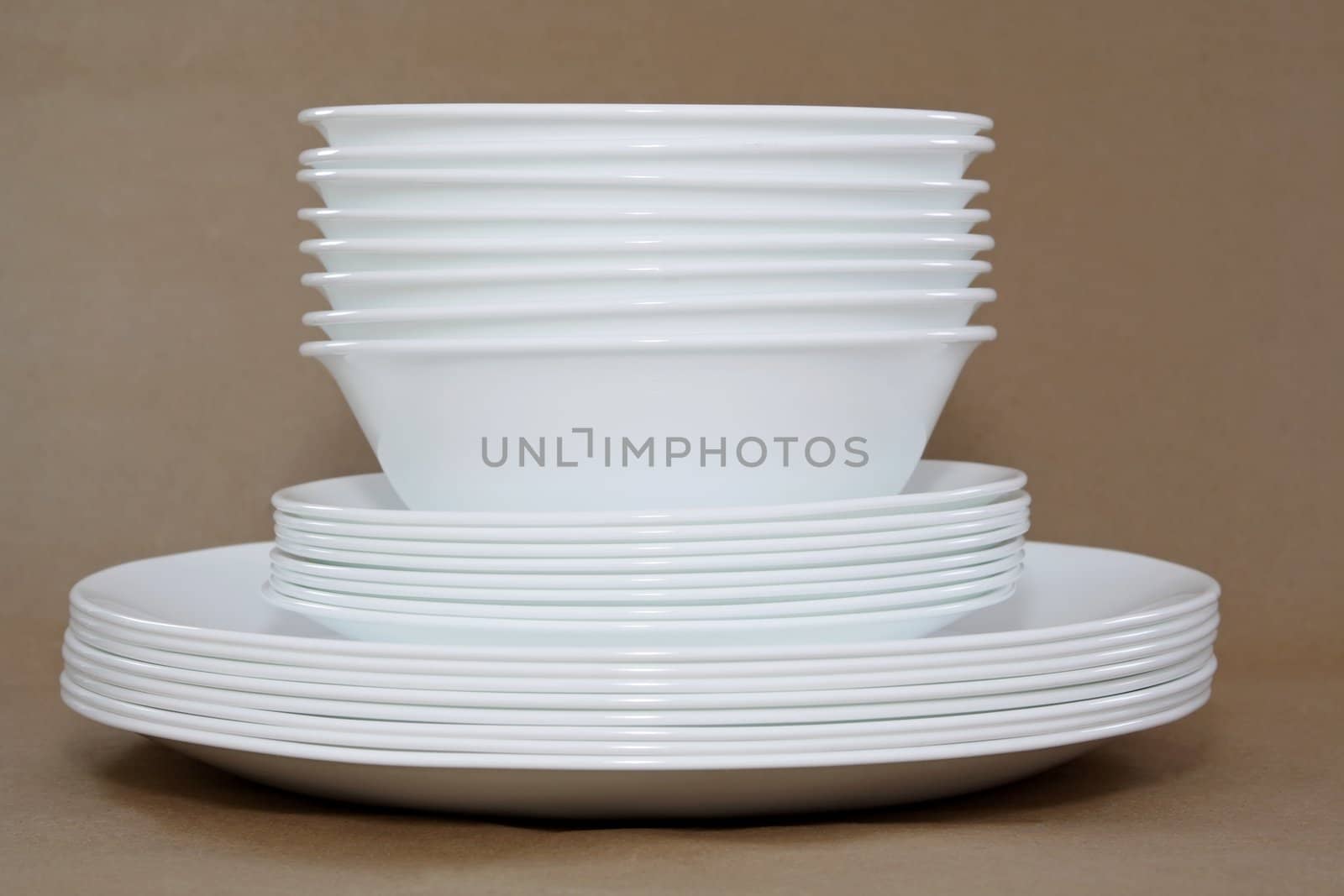 white dishes stacked, brown background