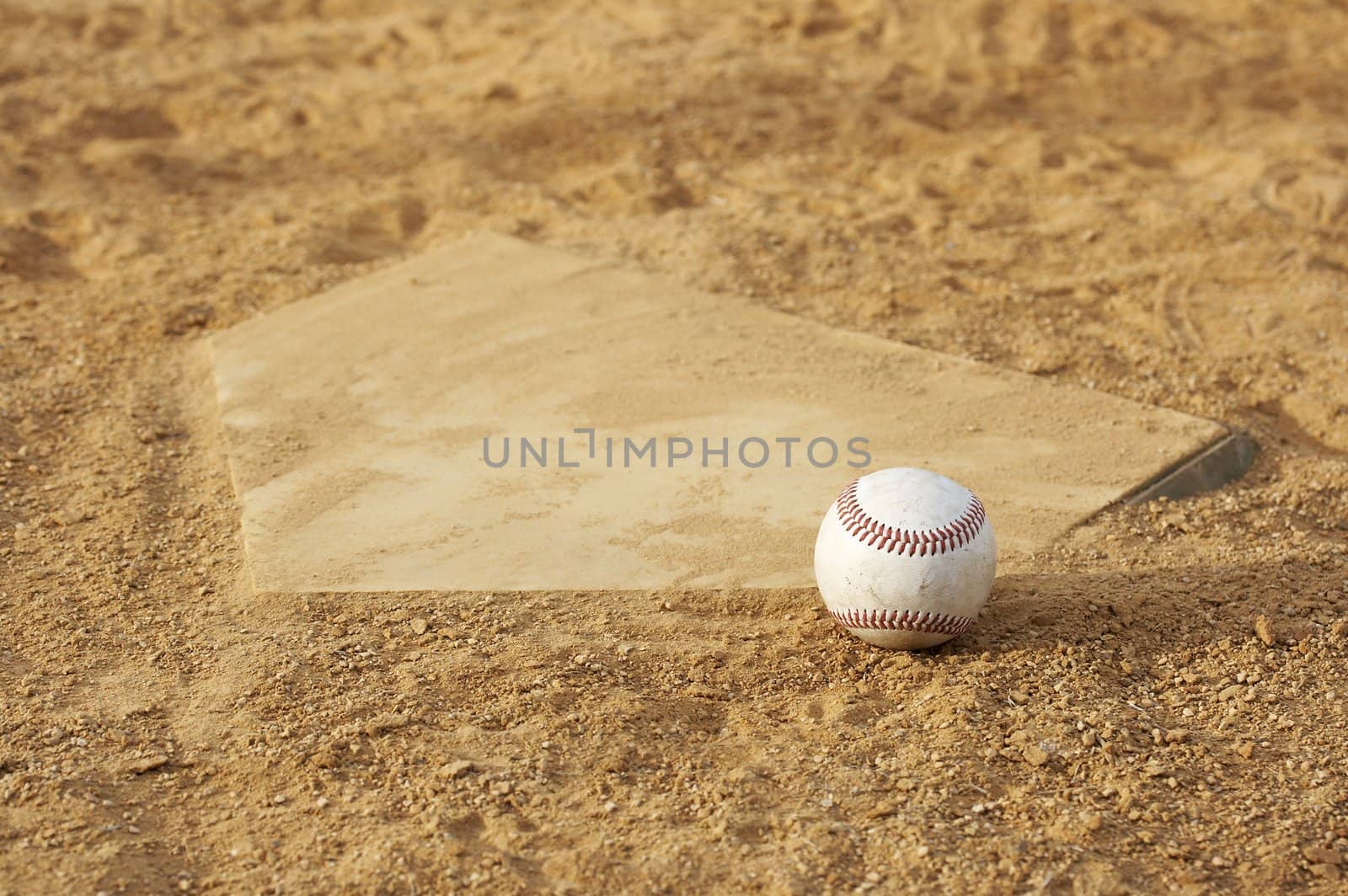 one baseball on home plate at a sports field