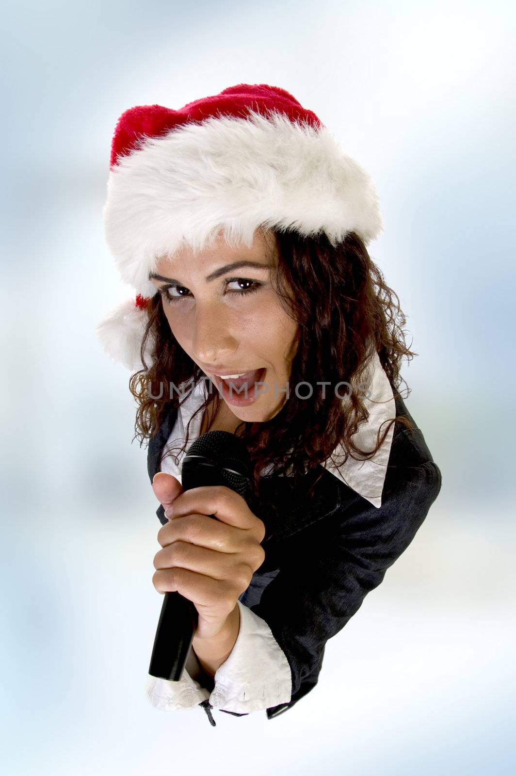 lady wearing christmas hat and singing into microphone on an abstract  background