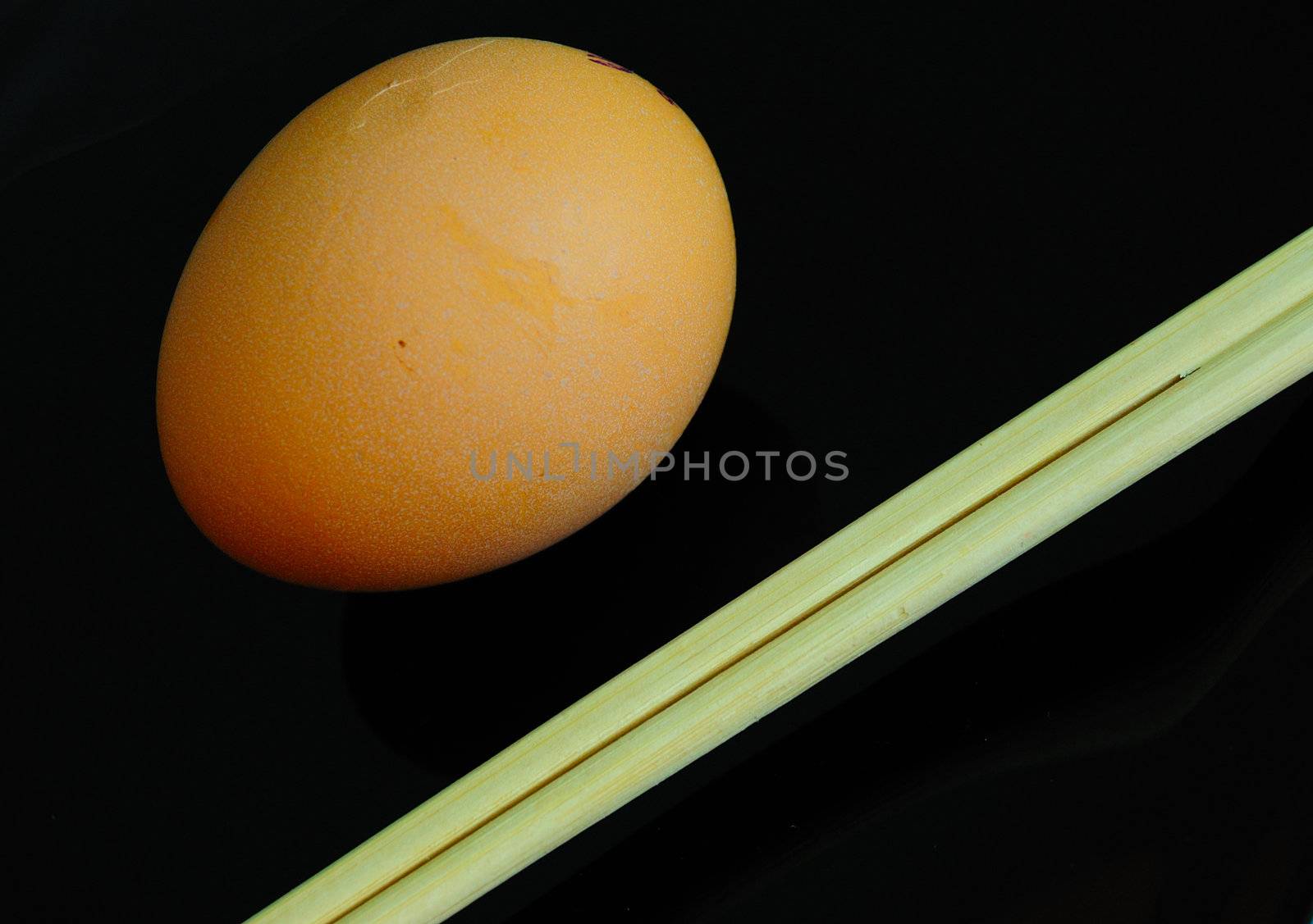 irony asian diet concept - raw and little bit - egg on black plate and chopsticks