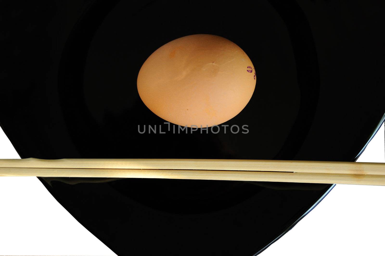 irony asian diet concept - raw and little bit - egg on black plate and chopsticks