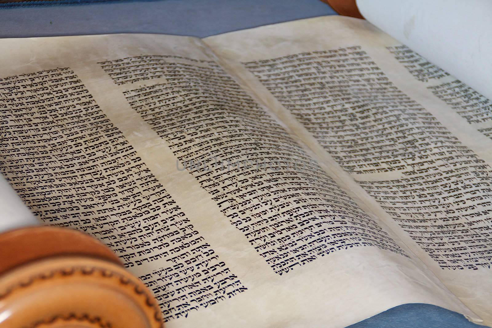 The hebrew Torah, displayed here on a synagogue alter, is hand written on goat skin parchement by a specially trained scribe using a feather quill