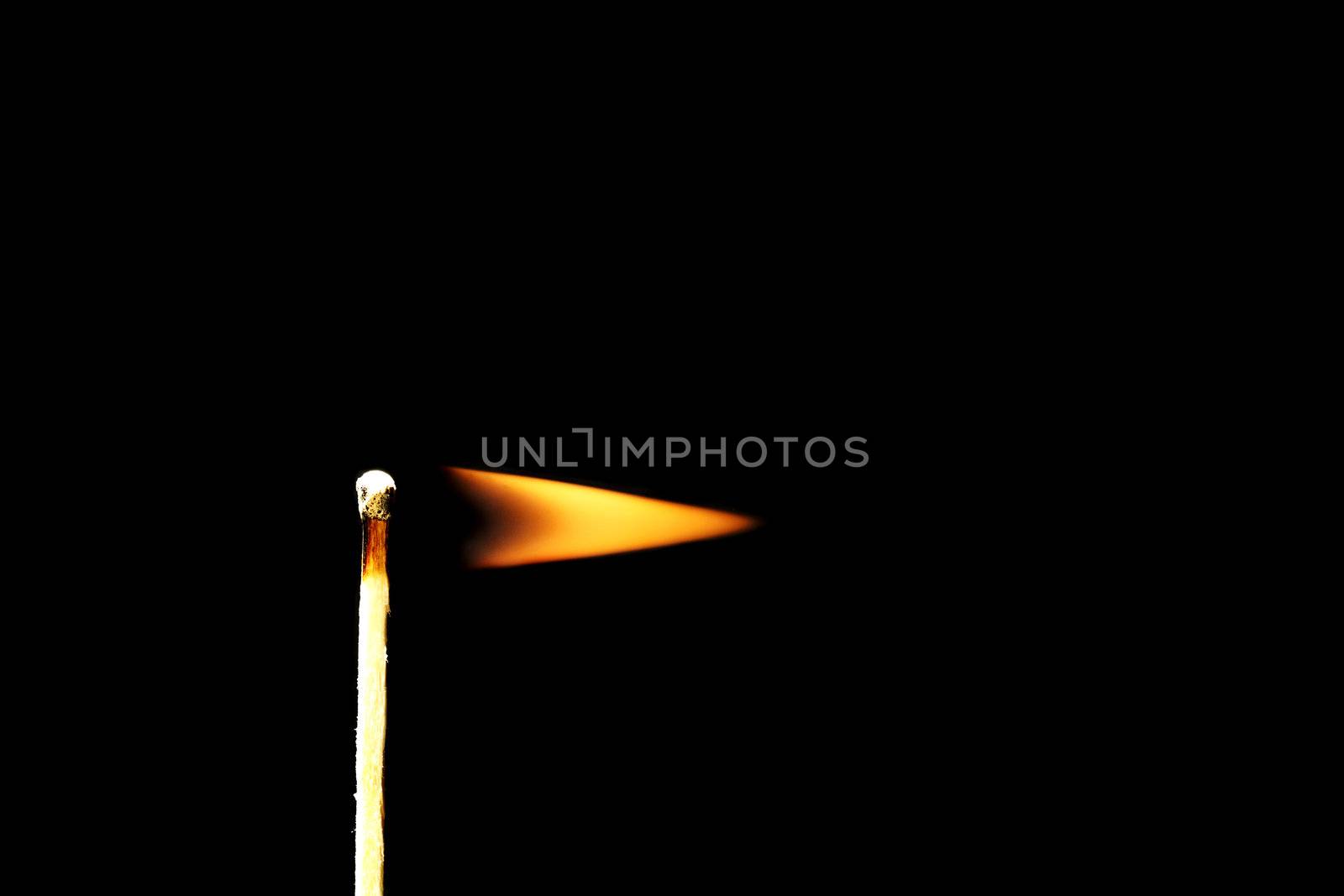 one burning match used as flag in front of black background