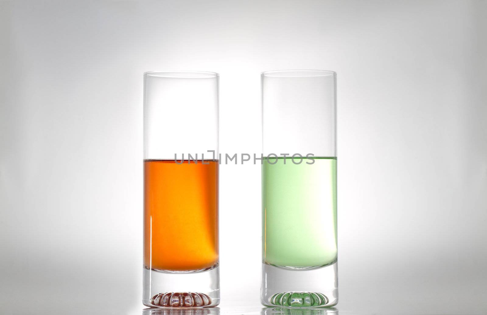 two glasses with red and green liquids