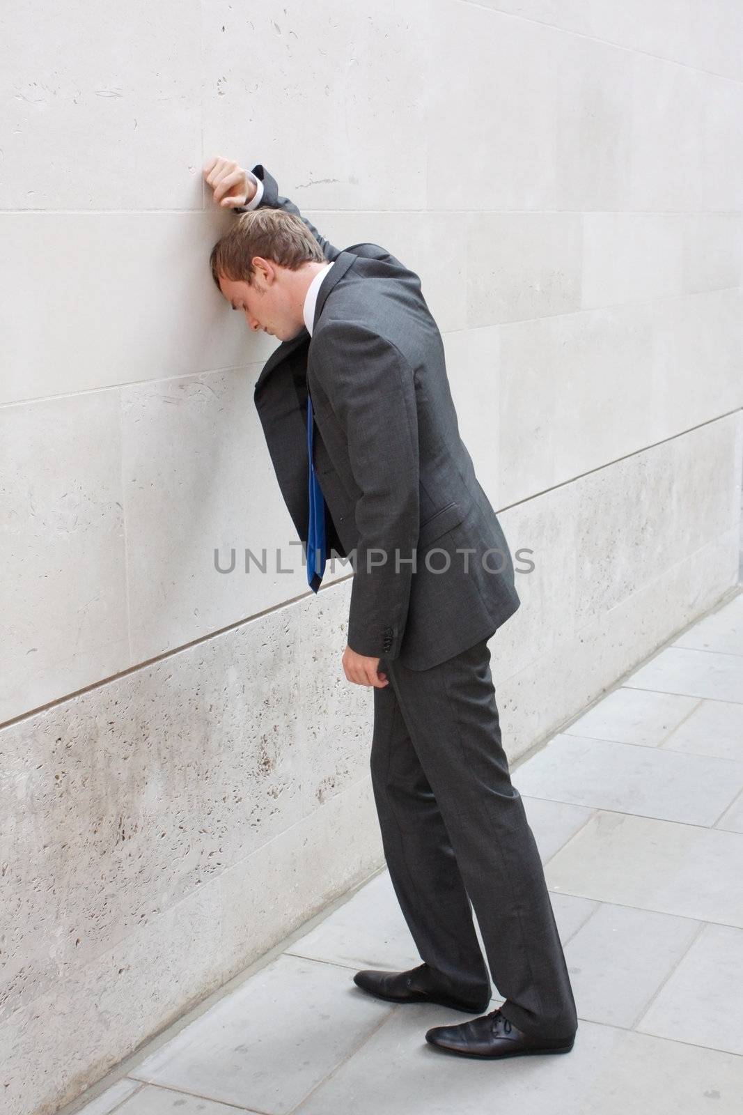 A worried business man sitting on some stairs