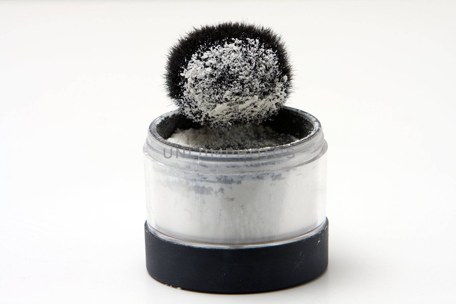 Translucent white powder in a jar and on brush, isolated