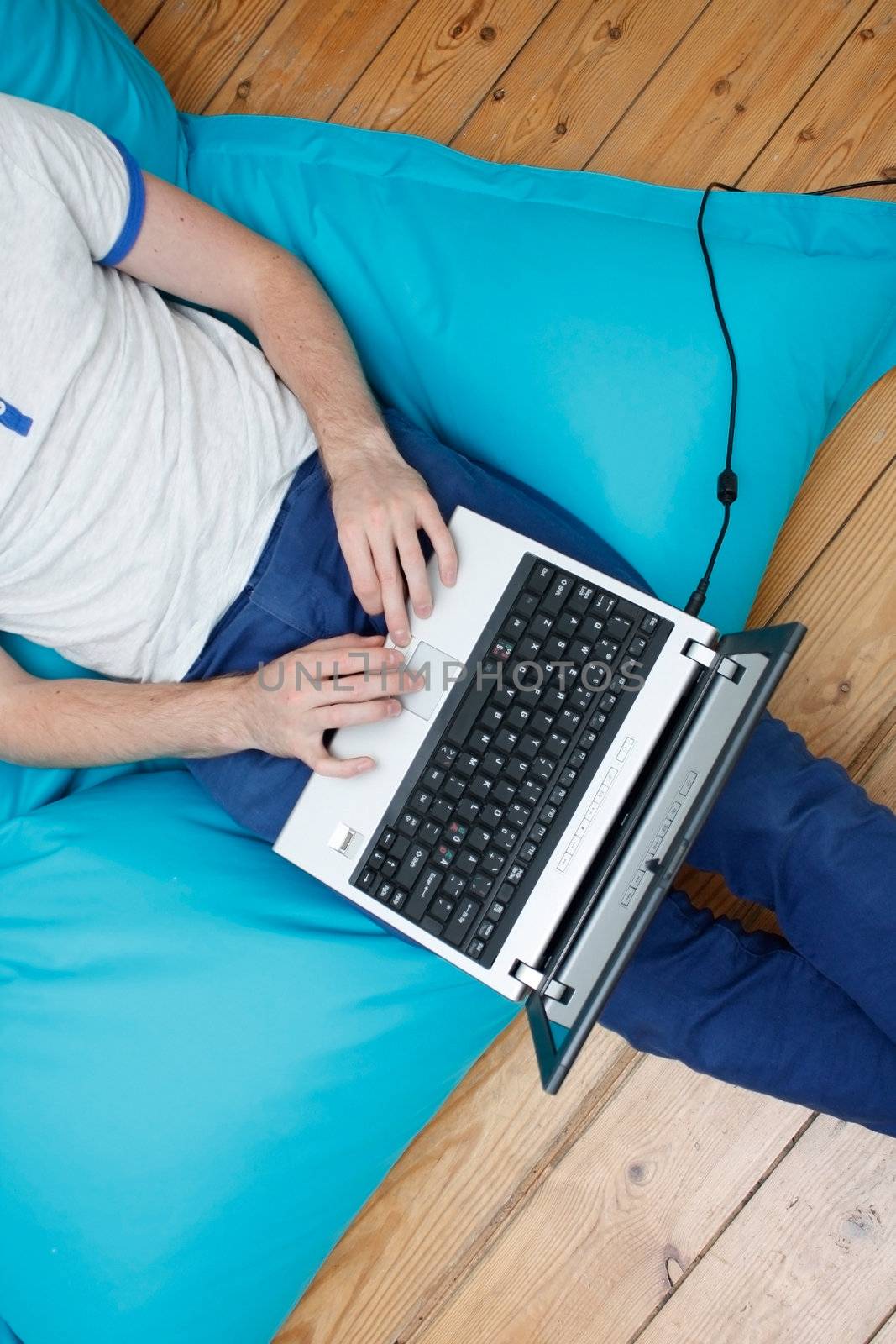 A teenager with a laptop computer on his lap