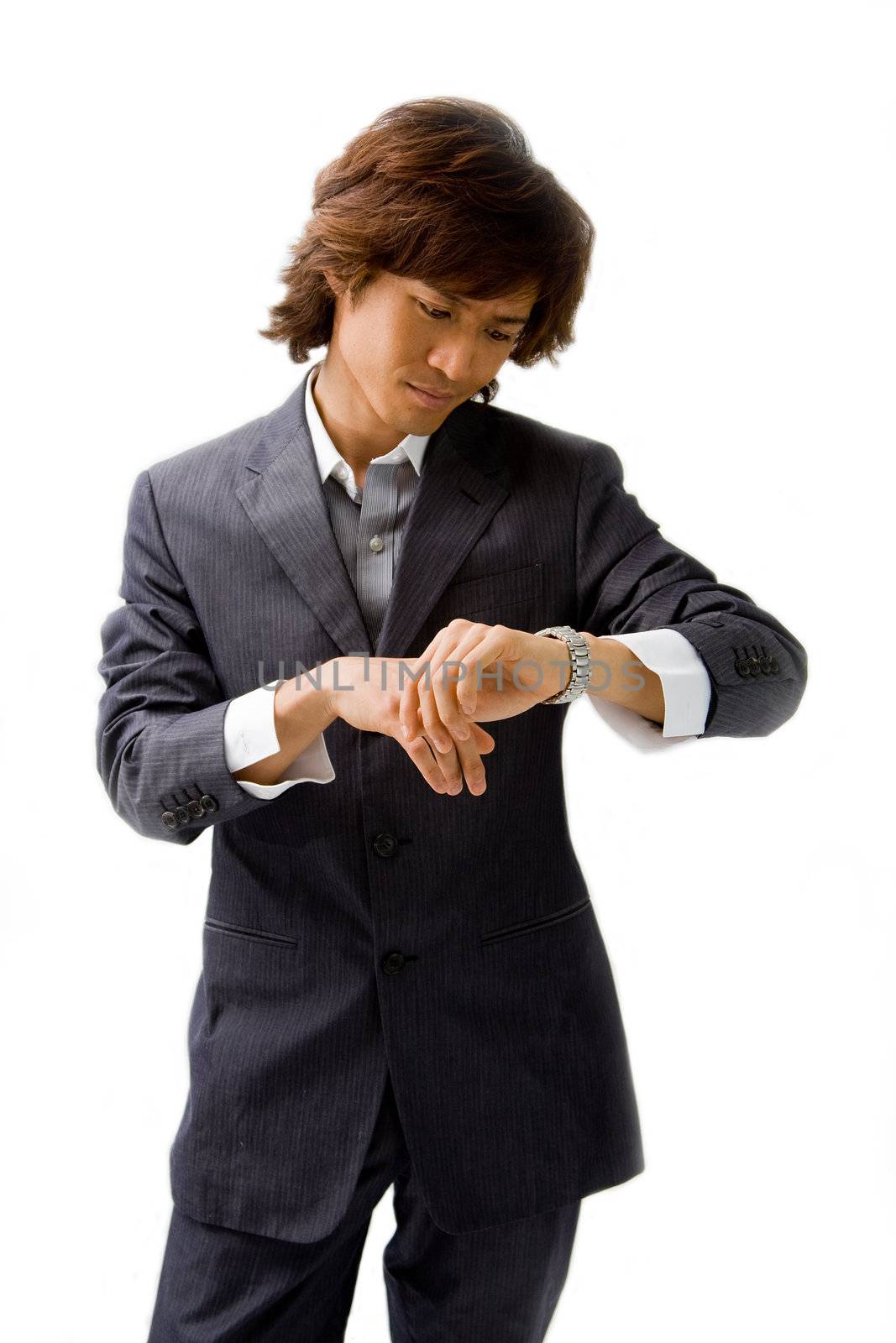 Young Asian business man dressed in a gray pinstripe suit checking time by looking at his watch, isolated