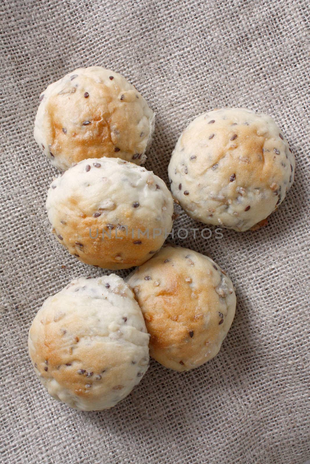 Delicious newly baked buns on background