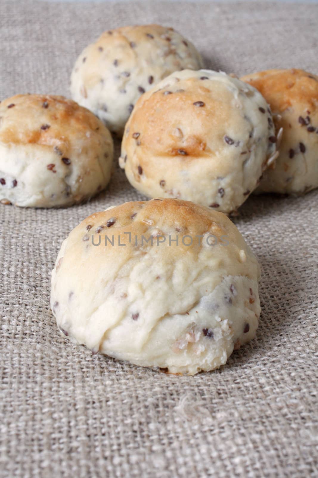 Delicious newly baked buns on background