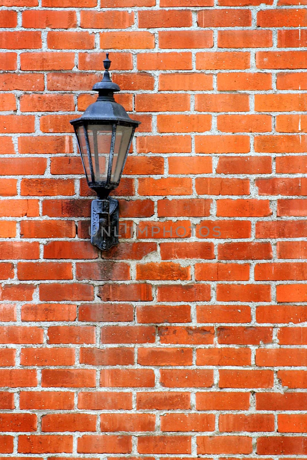 Old street light on a red brick wall.