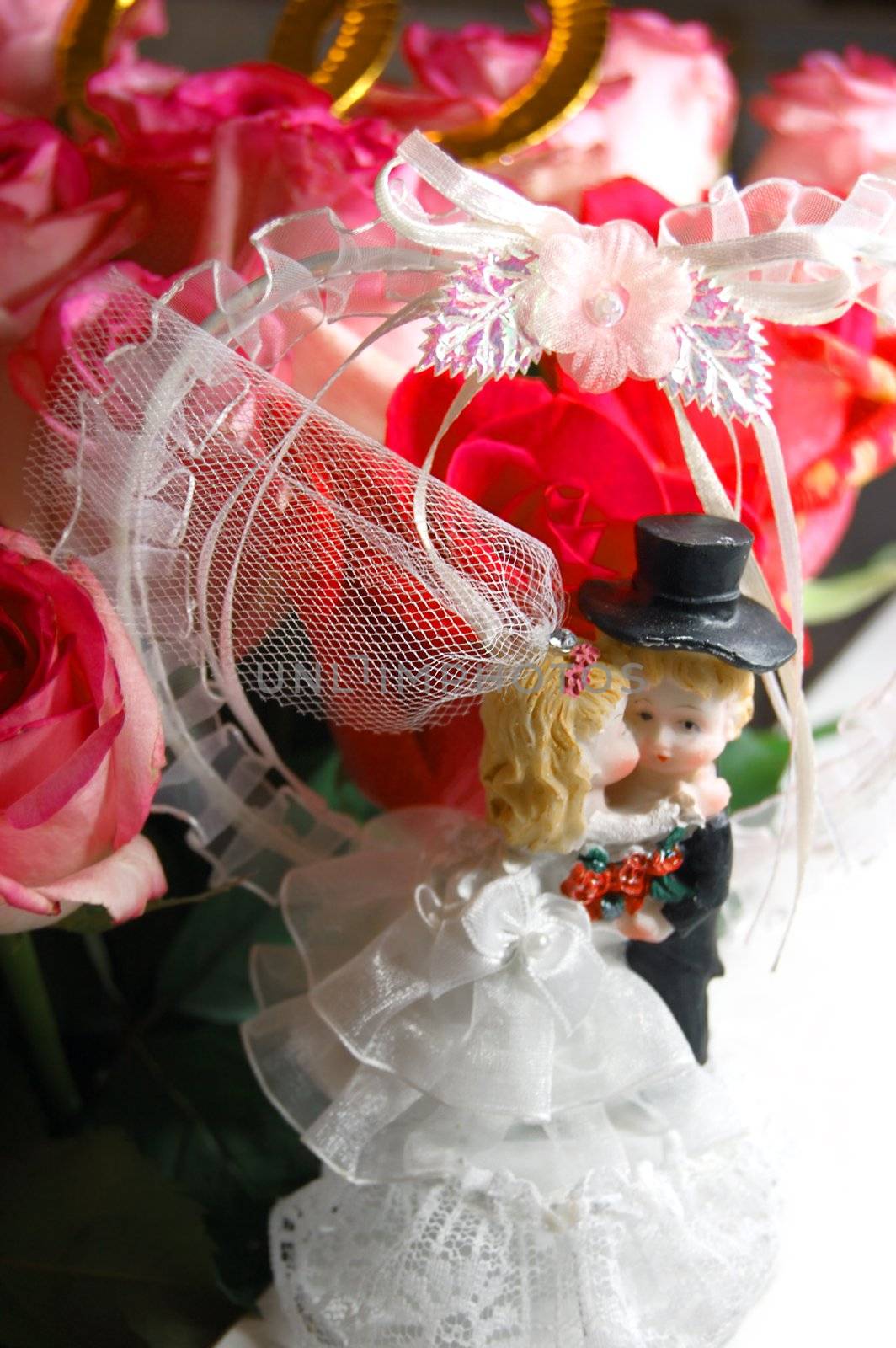 figurine of bride and groom kissing over wedding background