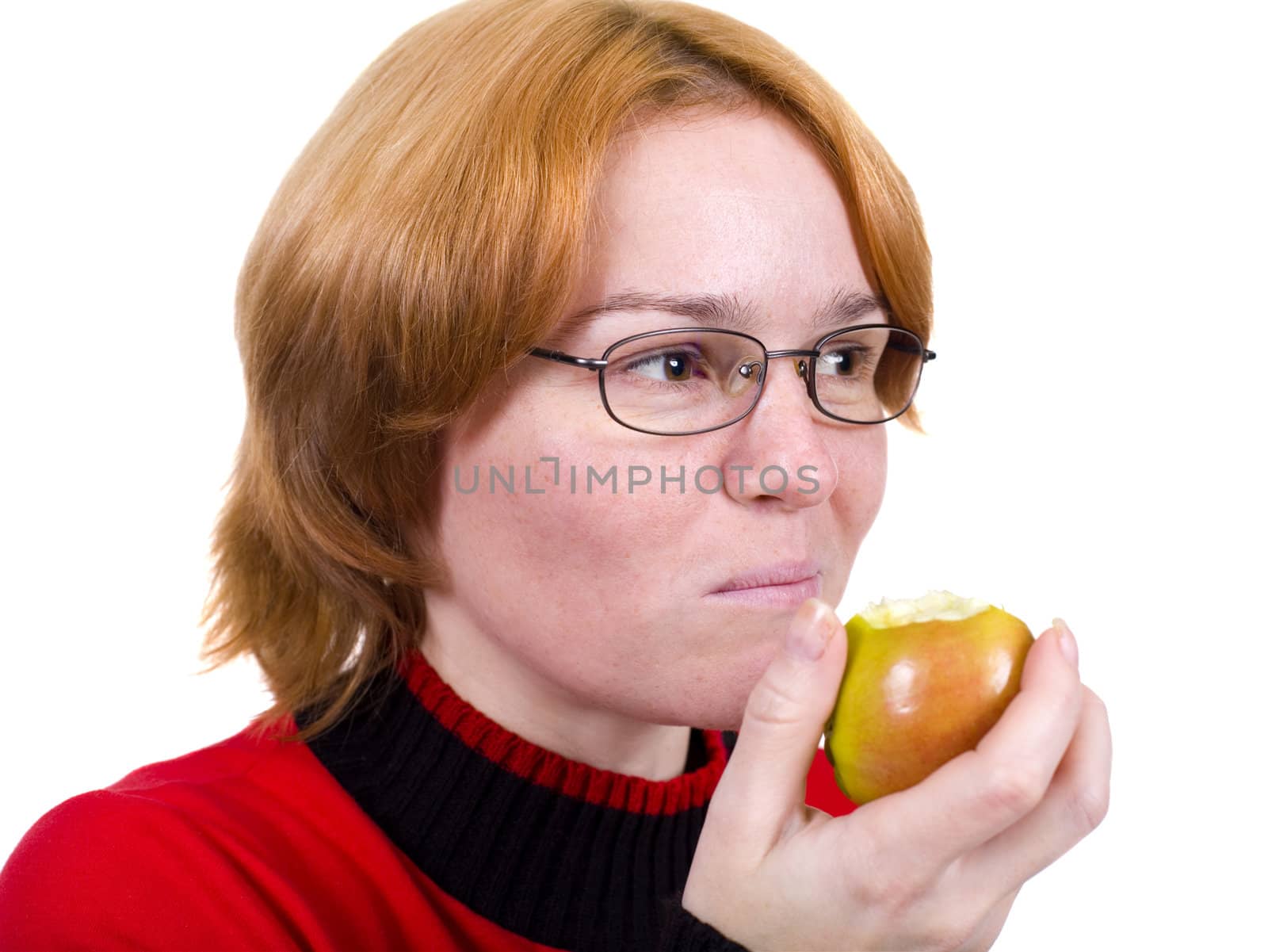 The girl in a red sweater eats an green apple