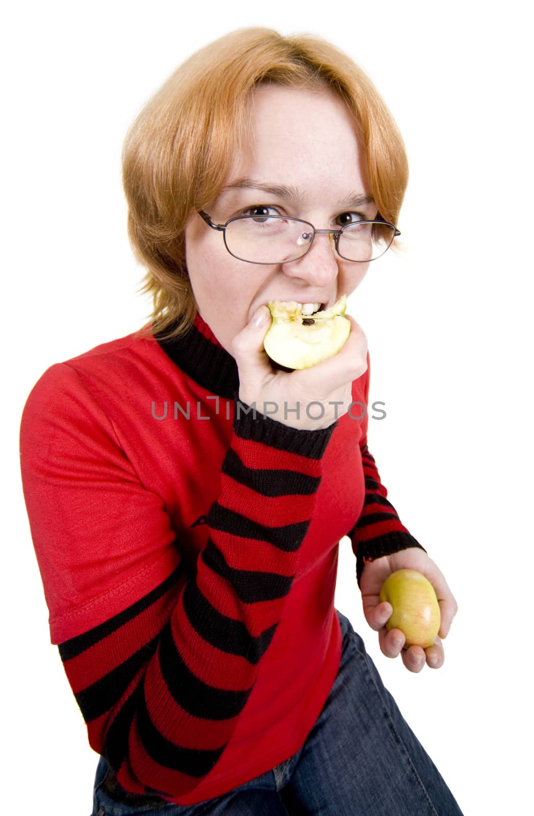 The girl in a red sweater eats an two apples