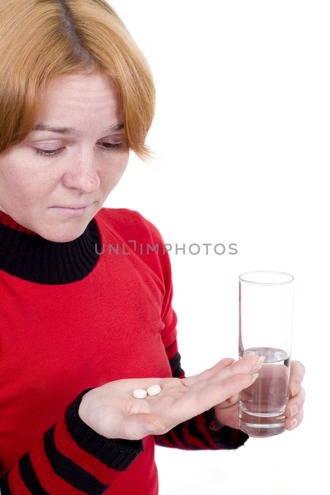 The sick girl with tablets and a glass