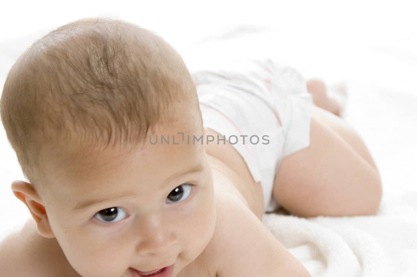 happy child lying and looking at camera on an isolated white background