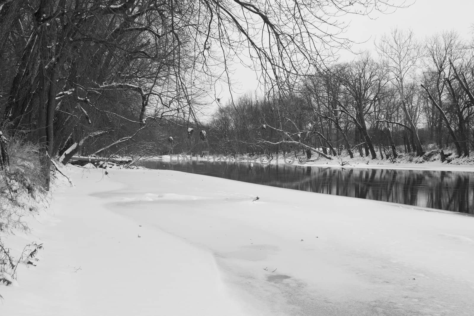 A half frozen river in black and white.
