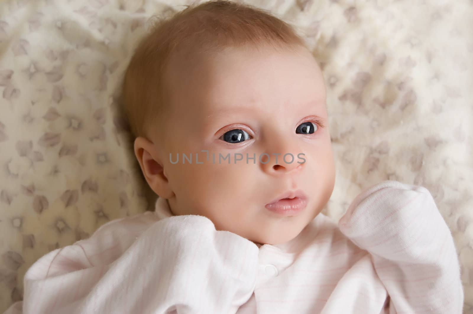 Cute baby girl lying on bed