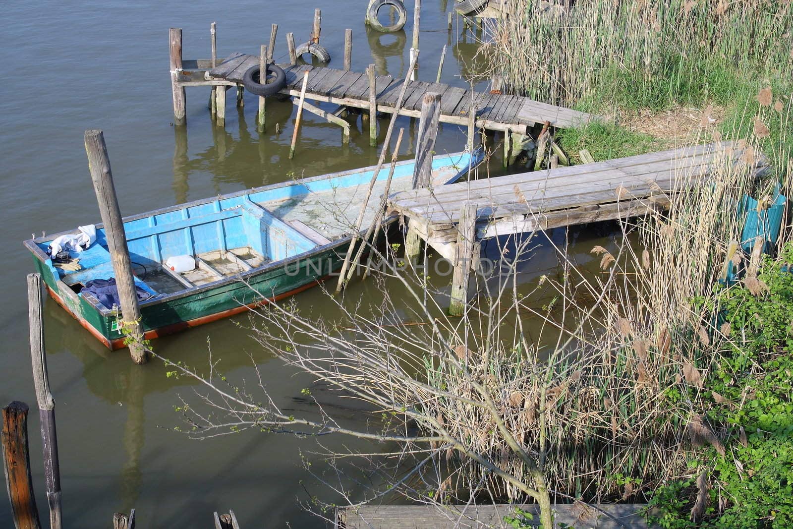 blue and wooden rowboat parked in a river