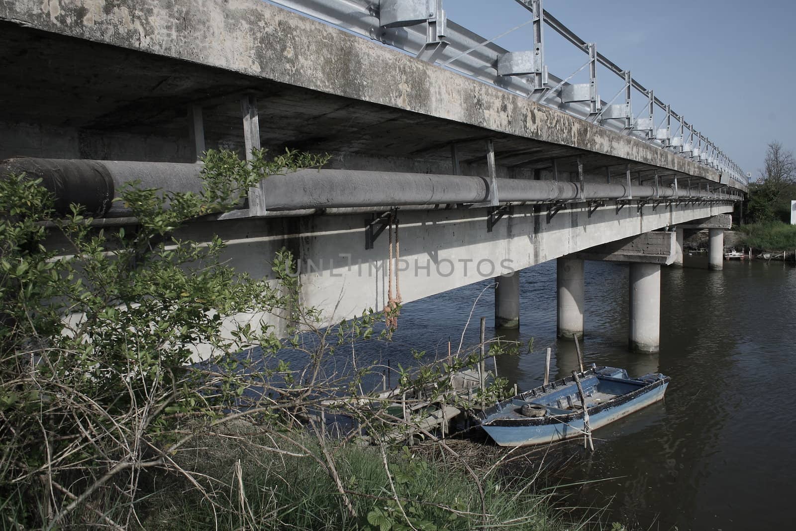 long bridge acrossing a river whit a little boat